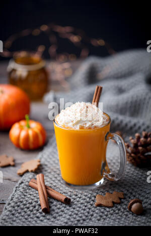 Kürbis Latte mit Gewürzen. Versoffenes Cocktail mit Schlagsahne. Grauer Hintergrund. Platz kopieren Stockfoto