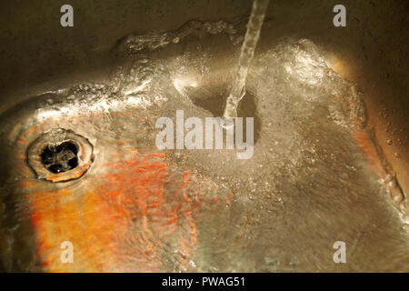 Wasser in der Spüle, in der Nähe auf. Szene Spritzwasser gießen stark von Wasser mit viel Wasser Blasen in der Wanne auf Küche aus Edelstahl Stockfoto