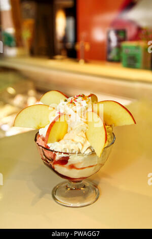 Eisbecher mit Wald Obst und Süßigkeiten schmilzt in ein hohes Becherglas, Nahaufnahme. Handgemachtes Eis Dessert. Eiscafé, Konditorei. Stockfoto