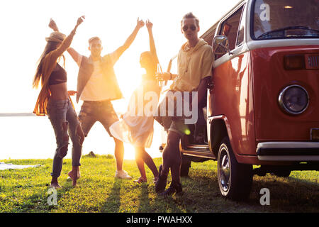 Sommer Urlaub, Reise, Urlaub, Reisen und Menschen Konzept - lächelnden Jungen hippie Freunde Spaß über minivan Auto Stockfoto