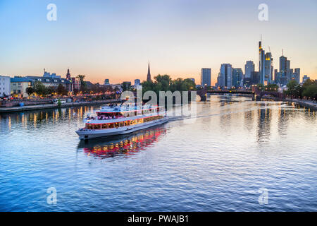 Abend City Skyline von moderner Architektur, touristischen Boot segeln durch die Brücke über den Main, Frankfurt, Deutschland Stockfoto