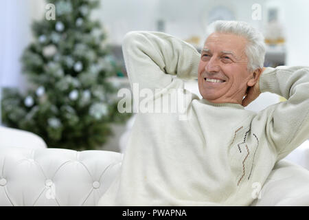 Porträt von einem älteren Mann sitzt auf einem Sofa Stockfoto