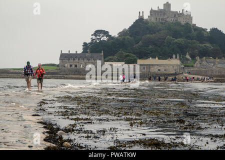 Touristen über den Causeway nach St. Michael's Mount, während es von der Flut überschwemmt wird, Cornwall, Großbritannien Stockfoto
