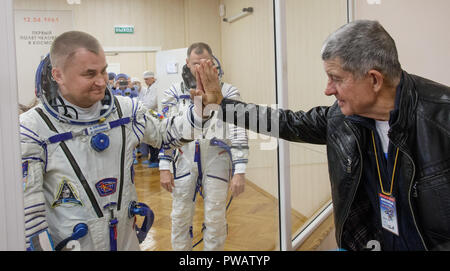 Expedition 57 Bordingenieur Alexey Ovchinin von roskosmos nimmt Abschied von seinem Vater, nachdem er seine Sokol Anzug Druck vor seinem Start einer Sojus-Rakete mit Flugingenieur Nick Haag der NASA geprüft, auf dem Kosmodrom Baikonur 11. Oktober, in Baikonur, Kasachstan 2018. Kurz nach dem Abheben der Rakete versagt auf dem Weg zur Internationalen Raumstation und Abgebrochen zwingt eine Notlandung in Kasachstan. Die Besatzungsmitglieder wurden von Suche und Rettung abgeholt und sind angeblich in gutem Zustand. Stockfoto