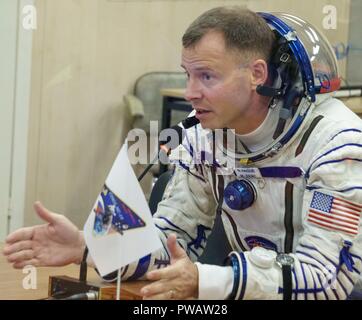 Expedition 57 Flight Engineer Nick Haag der NASA spricht mit seiner Familie nach seinem Sokol Anzug Druck geprüft Vor seinem Start einer Sojus-Rakete mit Flugingenieur Alexey Ovchinin von Roskosmos, am Kosmodrom Baikonur 11. Oktober, in Baikonur, Kasachstan 2018. Kurz nach dem Abheben der Rakete versagt auf dem Weg zur Internationalen Raumstation und Abgebrochen zwingt eine Notlandung in Kasachstan. Die Besatzungsmitglieder wurden von Suche und Rettung abgeholt und sind angeblich in gutem Zustand. Stockfoto