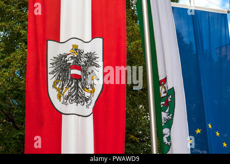 Österreichische Fahne mit Wappen entwickelt sich im Wind Stockfoto