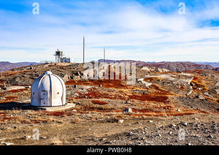 Metall Bunker mit meteorologischen Station und Herbst Grönländisch orange Tundra Landschaft mit Bergen im Hintergrund, Kangerlussuaq, Grönland Stockfoto