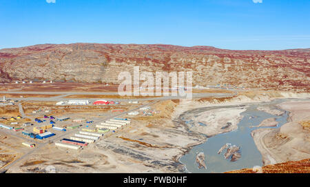 Antenne Panorama des lebendigen Bausteinen und Start- und Landebahn des Flughafen Kangerlussuaq, mit schlammigen Gletscherfluss im Vordergrund, Grönland Stockfoto