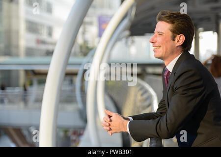 Profil anzeigen von Happy Geschäftsmann, lächeln und denken in footbr Stockfoto