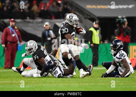 London, Großbritannien. 14. Oktober 2018. Zurück läuft Jalen Richard (30) von Oakland ist durch defensive Angriff Angriff Jarran Reed (90) von Seattle. Seattle Seahawks an der Oakland Raiders NFL Spiel im Wembley Stadium, das erste der NFL London 2018 Spiele. Endstand Seahawks 27 Räuber 3. Credit: Stephen Chung/Alamy leben Nachrichten Stockfoto