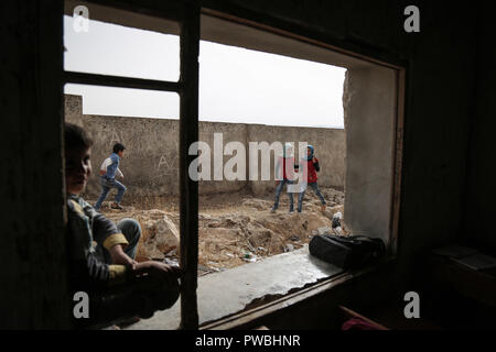 Tur Laha, Syrien. 15 Okt, 2018. Syrische Schulkinder zu Fuß außerhalb der Klassenräume einer Schule im Dorf Tur Laha auf der Syrian-Turkish Grenze. Die Fernbedienung verarmten Schule, die fast 200 Studenten der Anwohner und der Vertriebenen, ist auf einem Berg und es fehlen die notwendigen Mittel für die Bereitstellung von Bildung unter schwierigen Bedingungen, mit der kommenden Wintersaison zusammenfallen. Credit: Anas Alkharboutli/dpa/Alamy leben Nachrichten Stockfoto