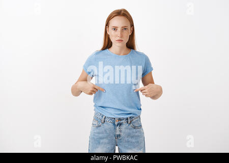 Sie glauben, dass es lustig ist. Porträt von Ernst unzufrieden und intensiven rothaarige Frau mit ernsten Gespräch mit Freund stirnrunzelnd Suchen unemotional zeigen auf Bauch mit Index Finger Stockfoto