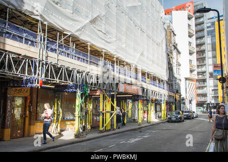 Ein Gitarrist Wanderungen vorbei an verlassenen Musik Shops auf Dänemark Straße, das ehemalige Haus der britischen Musikindustrie, und einmal als Tin Pan Alley bekannt Stockfoto