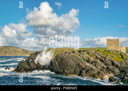 Bild von Wellen auf einer felsigen Küste vor einer Burg in Donegal Irland Stockfoto