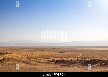 Panorama der Namak Salt Lake, von oben gesehen, mit einer Straße im Vordergrund sichtbar und ein Tal im Hintergrund, am Nachmittag, in Maranjab Stockfoto