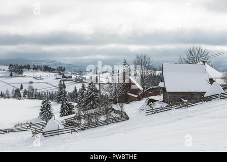 Alpine Village in Siebenbürgen, Rumänien. Schnee bedeckte Häuser im Winter Stockfoto