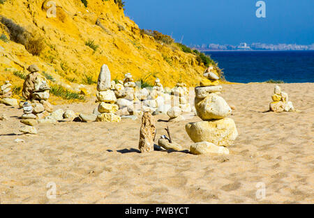 Rock Skulpturen auf einem verlassenen Teil der Praia da Oura Strand in Alburian an der Algarve in Portugal mit Vilamoura in der fernen Hintergrund Stockfoto