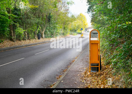 Temporäre Haltestellenschild in einem ländlichen Dorf mit Bäumen gesäumten Straße ohne Verkehr, hamstreet, Kent, Großbritannien Stockfoto