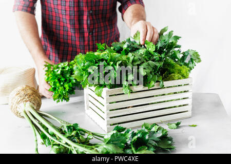Bauer mit frisch Kräuter in der Holzkiste auf weißer Tisch. Ernte Konzept Stockfoto
