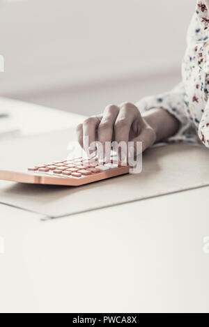 Retro Effekt verblasste und getönten Bild der weiblichen Buchhalter oder Banker, die Berechnungen auf orange Tischrechner. Stockfoto