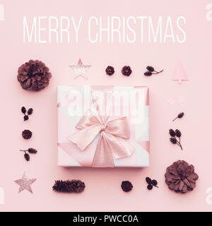 Pastellrosa minimal Weihnachten Hintergrund. Schöne Weihnachten Geschenk auf Pastell rosa Hintergrund isoliert. Rosa gefärbte gewickelt Xmas box Komposition. Stockfoto