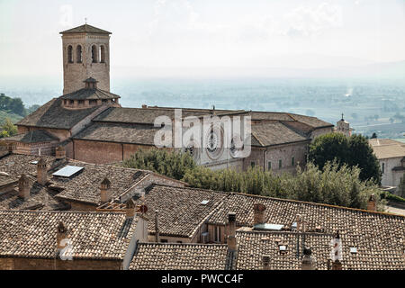 kirche und Glockenturm von San Pietro mit den Dächern von Assisi. Perugia, Umbrien, Italien Stockfoto