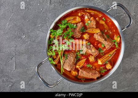 Ansicht von oben der köstlichen Rindfleisch und Okra Eintopf in eine Kasserolle auf einer konkreten Tabelle, Ansicht von oben, flach Stockfoto