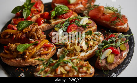 Einstellen der sortierten Bruschetta mit verschiedenen Toppings für Urlaub. Ansicht von oben. Party Food Konzept. Stockfoto