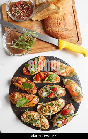 Einstellen der sortierten Bruschetta mit verschiedenen Toppings für Urlaub. Ansicht von oben. Party Food Konzept. Stockfoto