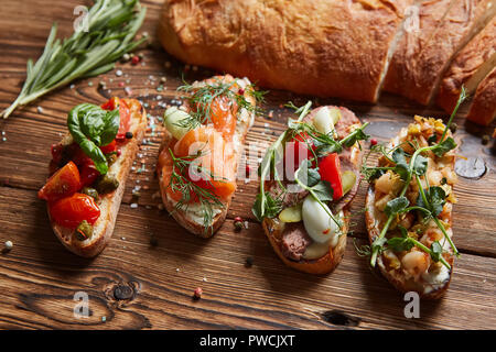 Einstellen der sortierten Bruschetta mit verschiedenen Toppings für Urlaub. Ansicht von oben. Party Food Konzept. Stockfoto