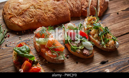 Einstellen der sortierten Bruschetta mit verschiedenen Toppings für Urlaub. Ansicht von oben. Party Food Konzept. Stockfoto