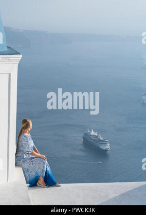 Glückliche Frau in weißen und blauen Dress ihr Urlaub auf Santorini, Griechenland genießen. Blick auf Caldera und die Ägäis von Imerovigli. Stockfoto