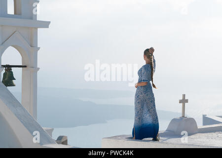 Glückliche Frau in weißen und blauen Dress ihr Urlaub auf Santorini, Griechenland genießen. Blick auf Caldera und die Ägäis von Imerovigli. Stockfoto