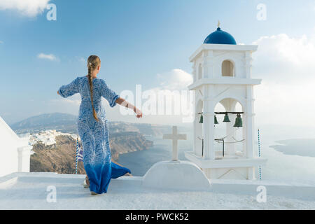 Glückliche Frau in weißen und blauen Dress ihr Urlaub auf Santorini, Griechenland genießen. Blick auf Caldera und die Ägäis von Imerovigli. Stockfoto