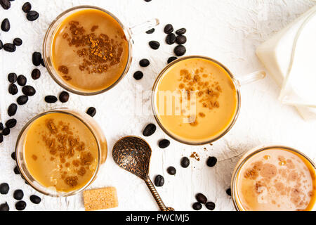 Tassen Kaffee und gerösteten Bohnen auf einem Tisch Stockfoto