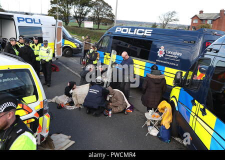 Ein Polizeiteam Schnitt einen Mann und eine Frau aus einem Satz Reifen, die sie offenbar mit ihren Armen in den Außengelände des Energieunternehmens Cuadrilla in Preston New Road, Little Plumpton, in der Nähe von Blackpool eingekert hatten. Fracking-Demonstranten haben gesagt, dass ihr Kampf gerade „ernst“ wurde, da der umstrittene Prozess in Lancashire beginnen soll. Stockfoto