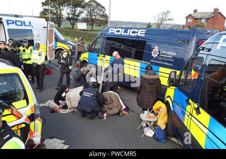 Ein Polizeiteam schneidet einen Mann und eine Frau aus einem Satz Reifen, die sie anscheinend mit ihren Armen auf dem Gelände des Energieunternehmens Cuadrilla in Preston New Road, Little Plumpton, in der Nähe von Blackpool eingekert hatten. Fracking-Demonstranten haben gesagt, dass ihr Kampf gerade „ernst“ wurde, da der umstrittene Prozess in Lancashire beginnen soll. Stockfoto