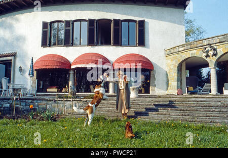 Sterben plant Maria Schell spielt im Garten mit Stand Hunden, Ca. 1979. Schauspielerin Maria Schell spielen mit ihren Hunden im Garten, Ca. 1979. Stockfoto