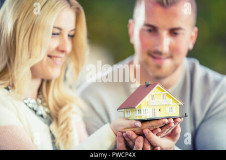 Junge liebende Paar hält kleine Modell Haus. Stockfoto