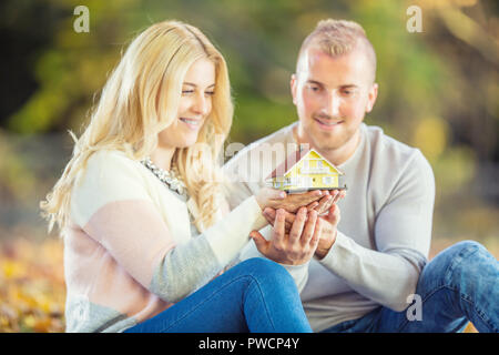 Junge liebende Paar hält kleine Modell Haus. Stockfoto