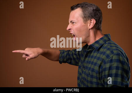 Studio shot des Menschen gegen den braunen Hintergrund Stockfoto