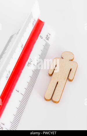 Makro kleine Laser-cut Holzfigur und Lineal. Metapher Messen persönliche Leistung, Demographie Konzept, Produktivität, die Maßnahme von einem Mann bekommen. Stockfoto