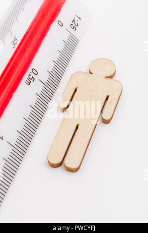 Makro kleine Laser-cut Holzfigur und Lineal. Metapher Messen persönliche Leistung, Demographie Konzept, Produktivität, die Maßnahme von einem Mann bekommen. Stockfoto