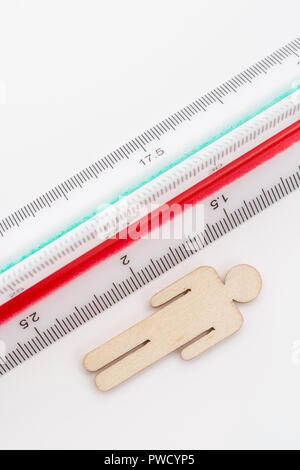 Makro kleine Laser-cut Holzfigur und Lineal. Metapher Messen persönliche Leistung, Demographie Konzept, Produktivität, die Maßnahme von einem Mann bekommen. Stockfoto