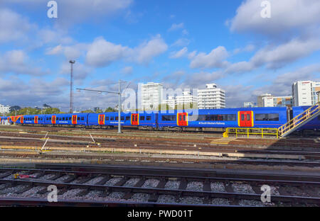 Bunte blau South Western Railway suburban Nahverkehrszug und Kutschen in Rangierbahnhofs in Clapham Junction Station, London, UK an einem sonnigen Tag Stockfoto