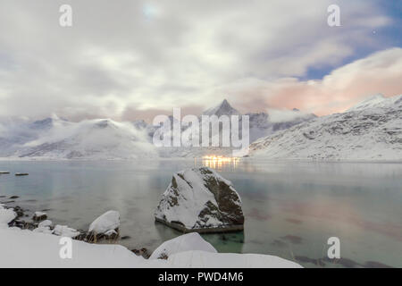 Lichter und Sterne leuchten die schneebedeckten Gipfel im Meer Vareid Flakstad Nordland Lofoten in Nordnorwegen Europa Stockfoto