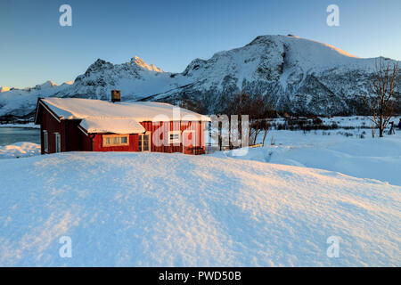 Die typisch norwegische Fischerhütte genannt Rorbu durch frischen Schnee, Svollvaer, Lofoten, Norwegen, Europa umgeben Stockfoto