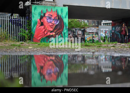 Shoreditch street art im späten Sommer Pfütze wider. Stockfoto