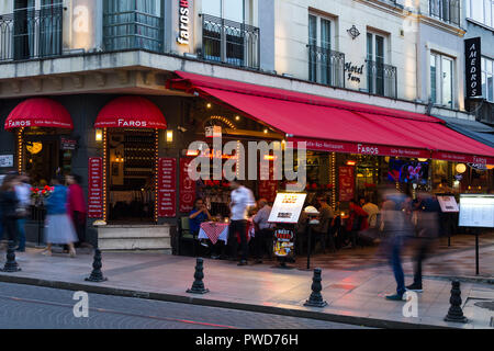 Ein Restaurant mit Außenbereich in der Dämmerung als Menschen gehen vorbei, Istanbul, Türkei Stockfoto