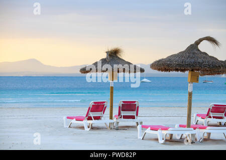 Leere Liegestühle und Sonnenschirme am Strand von Port de Alcudia Stockfoto